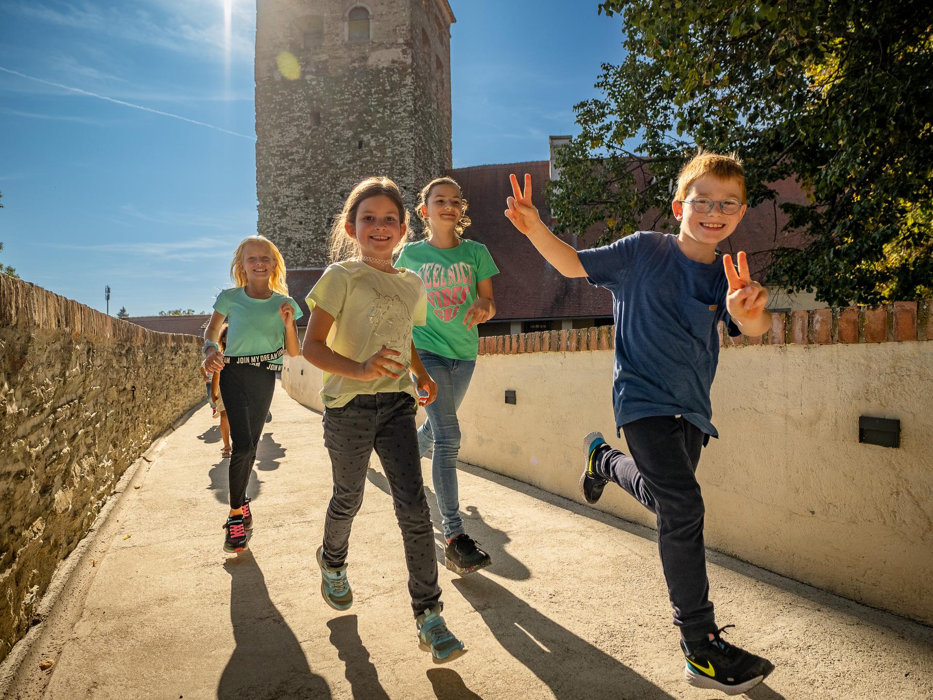 Kinder laufen über die Burgbrücke.