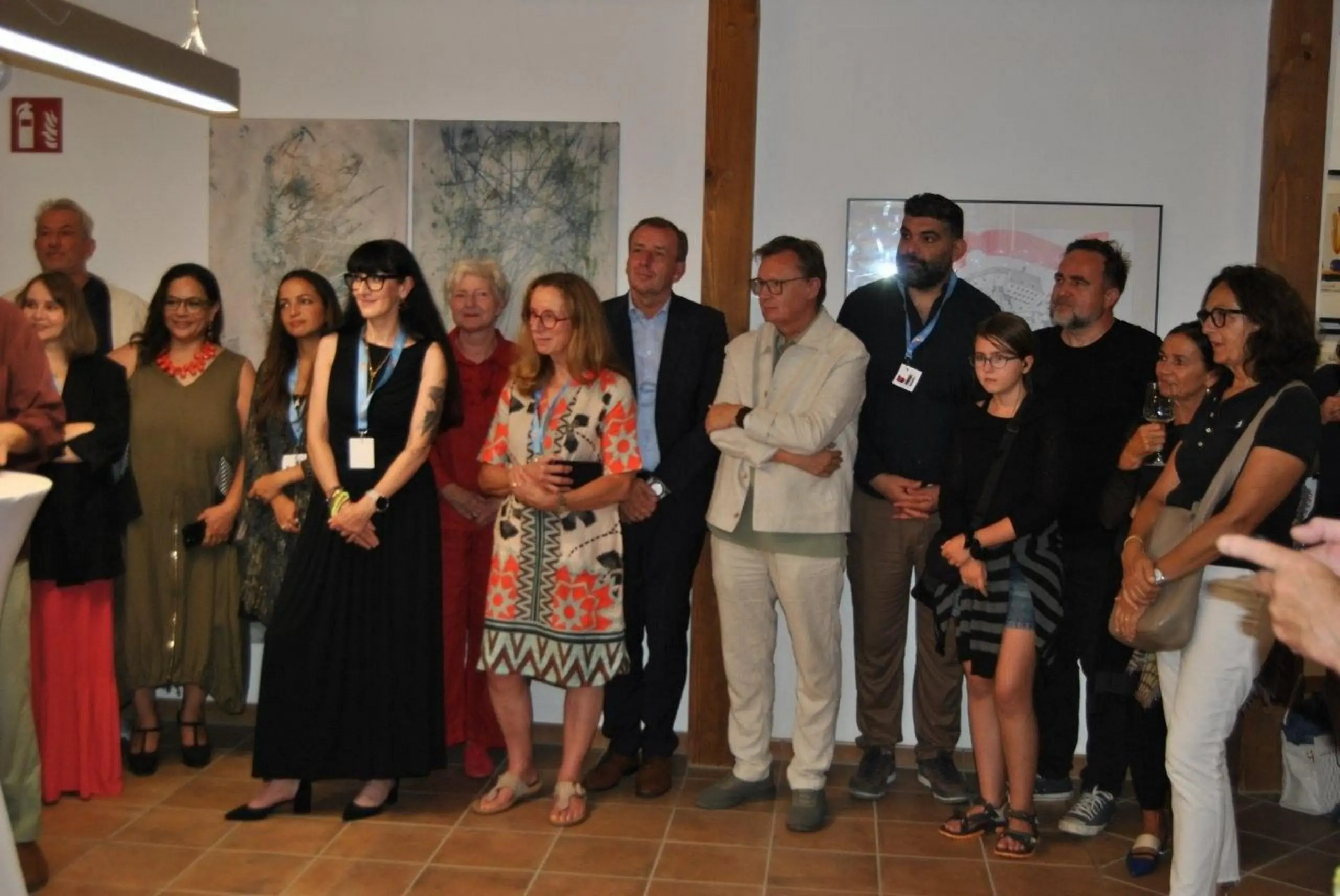 Gruppe von Personen steht in einem Ausstellungsraum vor Kunstwerken